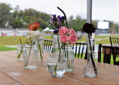 Mahogany Chiavari chairs with harvest tables and wildflower centerpieces at an outdoor event in Ocala, Florida.