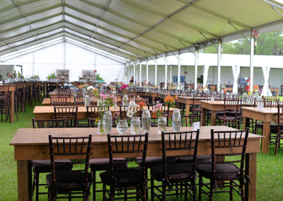 Mahogany Chiavari chairs with harvest tables and wildflower centerpieces at an outdoor event in Ocala, Florida.
