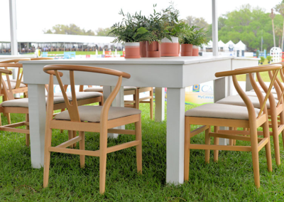 Wishbone chairs with white harvest table and terracotta pot centerpieces at an outdoor event in Ocala, Florida.
