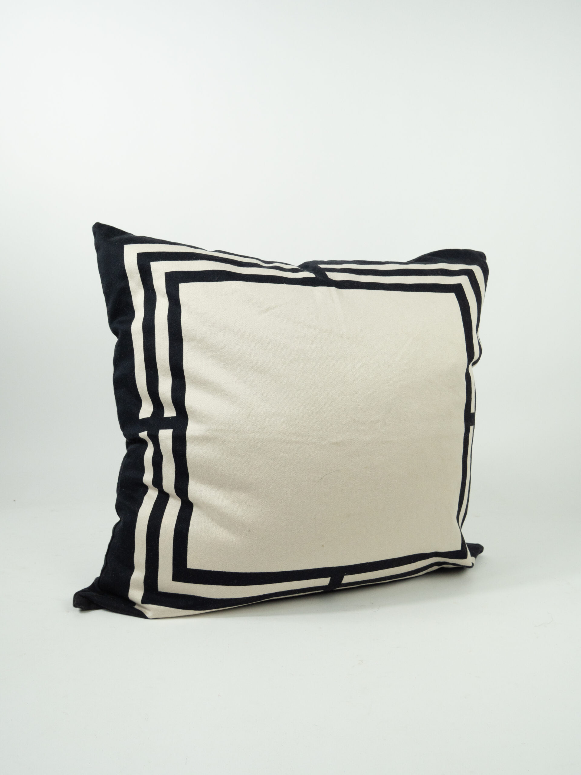 TAN PILLOW W/ BLACK BORDERS